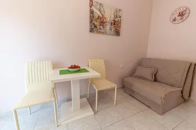 a living room with a table and chairs and a couch at Apartments Vjera Petrovac in Petrovac na Moru