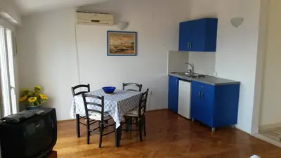 a small kitchen with a table and chairs in a room at Apartmani Drašković in Petrovac na Moru