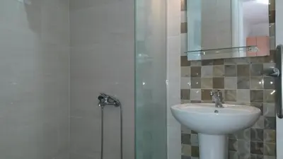 a bathroom with a sink and a shower at Apartmani Drašković in Petrovac na Moru