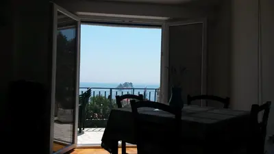 a room with a table and a view of the ocean at Apartmani Drašković in Petrovac na Moru