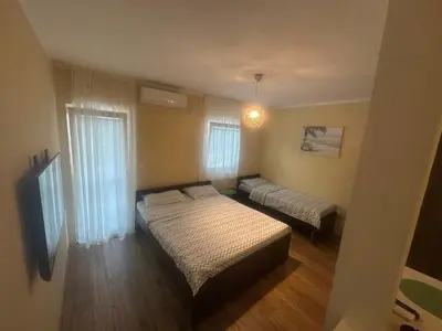 a small bedroom with two beds and a window at Home Šćekić in Budva