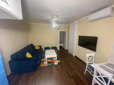 a living room with a blue couch and a table at Home Šćekić in Budva