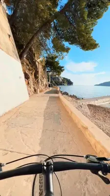 a bike parked on a beach next to the ocean at Home Šćekić in Budva