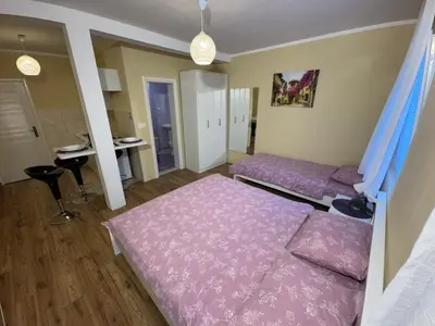 a bedroom with a pink bed and a couch at Home Šćekić in Budva