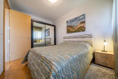 a bedroom with a bed and a dresser and a mirror at Apt 