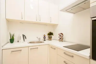 a kitchen with white cabinets and a sink at Apt 