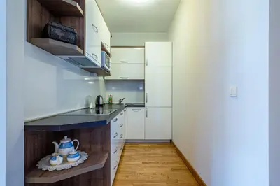 a small kitchen with white cabinets and a sink at Apt 