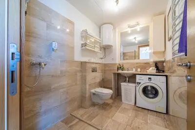 a bathroom with a toilet and a washer and dryer at Apt 