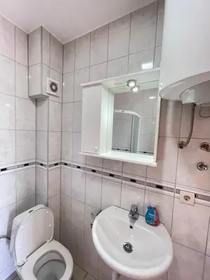 a bathroom with a white toilet and a sink at Apartments Vali in Ulcinj