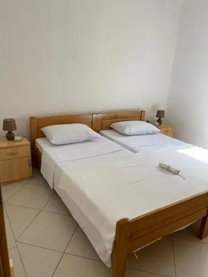 a bedroom with two beds with white sheets at Apartments Vali in Ulcinj
