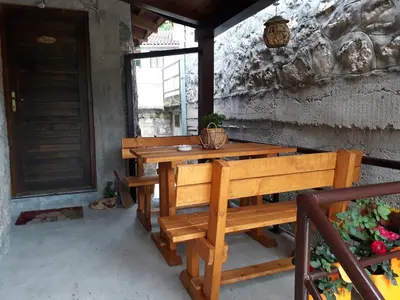 a wooden table and bench on a patio at Apartman Sofranac in Rijeka Crnojevića