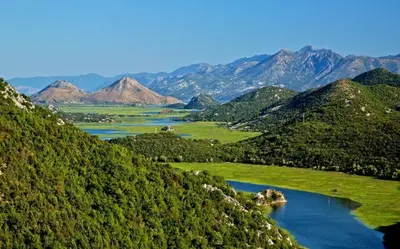 a view of a mountain range with a lake at Apartman Sofranac in Rijeka Crnojevića