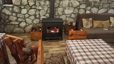 a living room with a fireplace and a couch at Village house - Novak Rijecani in Rijeka Crnojevića