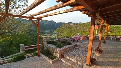 a patio with a view of a river and mountains at Village house - Novak Rijecani in Rijeka Crnojevića