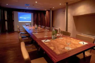a long table in a room with chairs and a screen at Boutique Hotel Astoria in Kotor