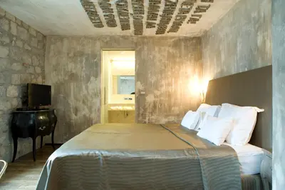 a bedroom with a bed and a desk and a television at Boutique Hotel Astoria in Kotor