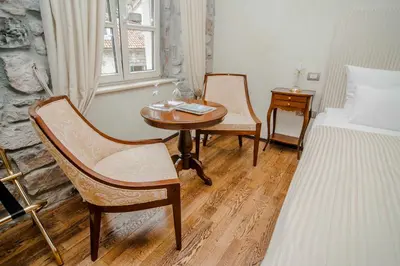 a bedroom with a table and chairs and a bed at Boutique Hotel Astoria in Kotor