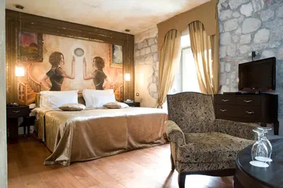 a hotel room with a bed and a chair at Boutique Hotel Astoria in Kotor