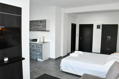 a bedroom with a white bed and a television at Flo Apartments in Ulcinj