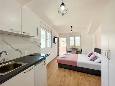 a bedroom with a bed and a kitchen with a sink at Jasmin apartmani in Bar