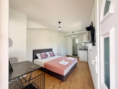 a small bedroom with a bed and a table at Jasmin apartmani in Bar