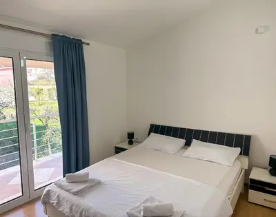 a bedroom with a bed and a large window at Jasmin apartmani in Bar