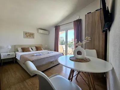 a bedroom with a bed and a table and a window at Jasmin apartmani in Bar