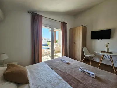 a bedroom with a bed with a view of a patio at Jasmin apartmani in Bar