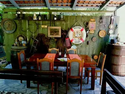 a dining room with a table and chairs and a clock at Guesthouse Berlin in Bar
