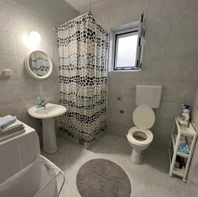 a bathroom with a toilet and a sink and a shower at Studio apartmani DENNUS in Bar