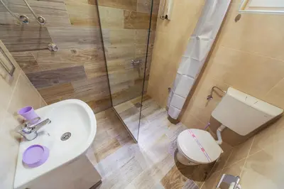 a bathroom with a toilet and a sink and a shower at Apartmani 