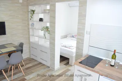 a small room with a bed and a table and a desk at Apartmani 
