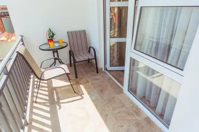 a balcony with a table and two chairs and a window at Apartmani 