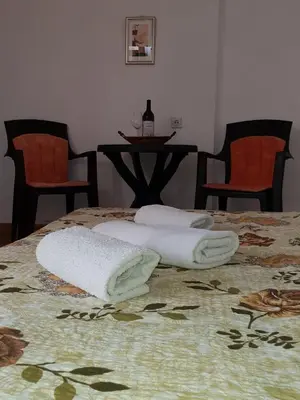 two towels sitting on top of a bed with two chairs at Apartments TODOR in Bar