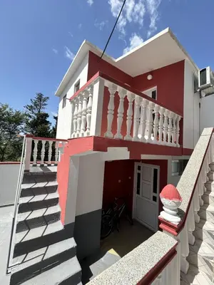 a house with a red and white facade at Apartments TODOR in Bar