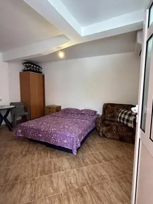 a bedroom with a purple bed and a couch at Apartments TODOR in Bar