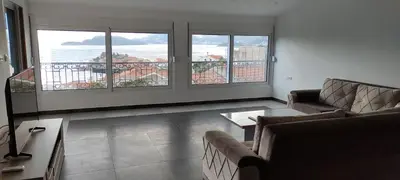 a living room with a view of the ocean at Zoran Apartments in Sveti Stefan