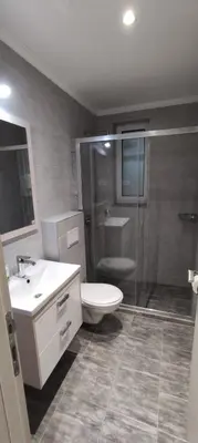 a bathroom with a toilet and a sink and a shower at Zoran Apartments in Sveti Stefan