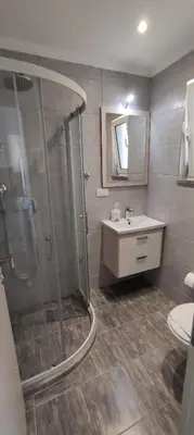 a bathroom with a shower and a sink at Zoran Apartments in Sveti Stefan