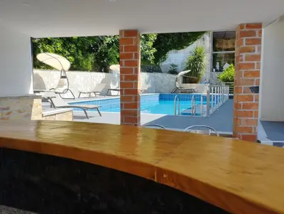 a wooden counter top in front of a swimming pool at Zoran Apartments in Sveti Stefan