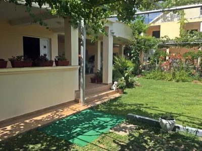 a yard of a house with a green lawn at Apartments Pelinkovic in Ulcinj