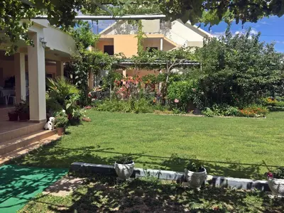 a yard of a house with a green lawn at Apartments Pelinkovic in Ulcinj