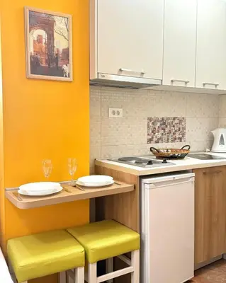 a kitchen with yellow walls and a counter with stools at Apartments Casa del Sol Jovana in Kotor