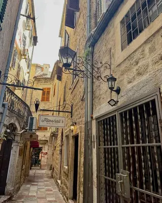 an alley in an old town with a sign on a building at Apartments Casa del Sol Jovana in Kotor