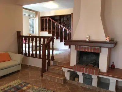a living room with a staircase and a fireplace at Villa Julia in Petrovac na Moru