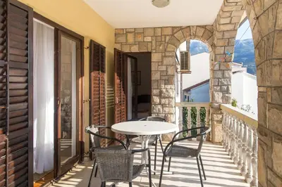 a patio with a table and chairs on a balcony at Guesthouse Blue Coast in Budva