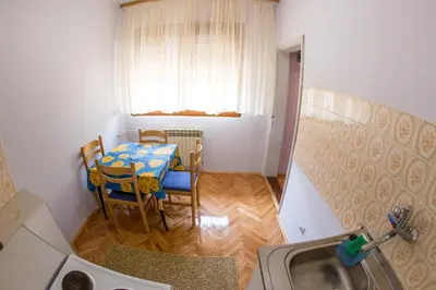 a kitchen with a table and chairs and a window at Guesthouse Blue Coast in Budva