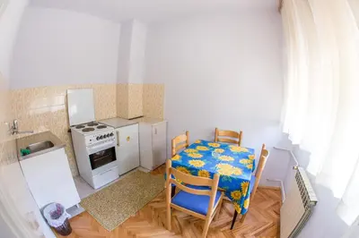 a kitchen with a table and chairs and a stove at Guesthouse Blue Coast in Budva