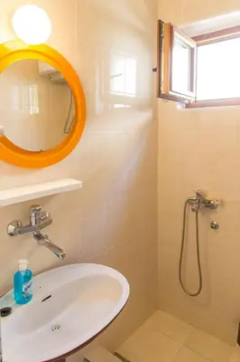 a bathroom with an orange mirror and a sink at Guesthouse Blue Coast in Budva