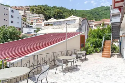 a patio with tables and chairs in a city at Guesthouse Blue Coast in Budva